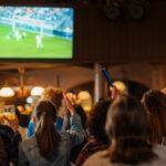 Soccer Club members celebrate in a pub