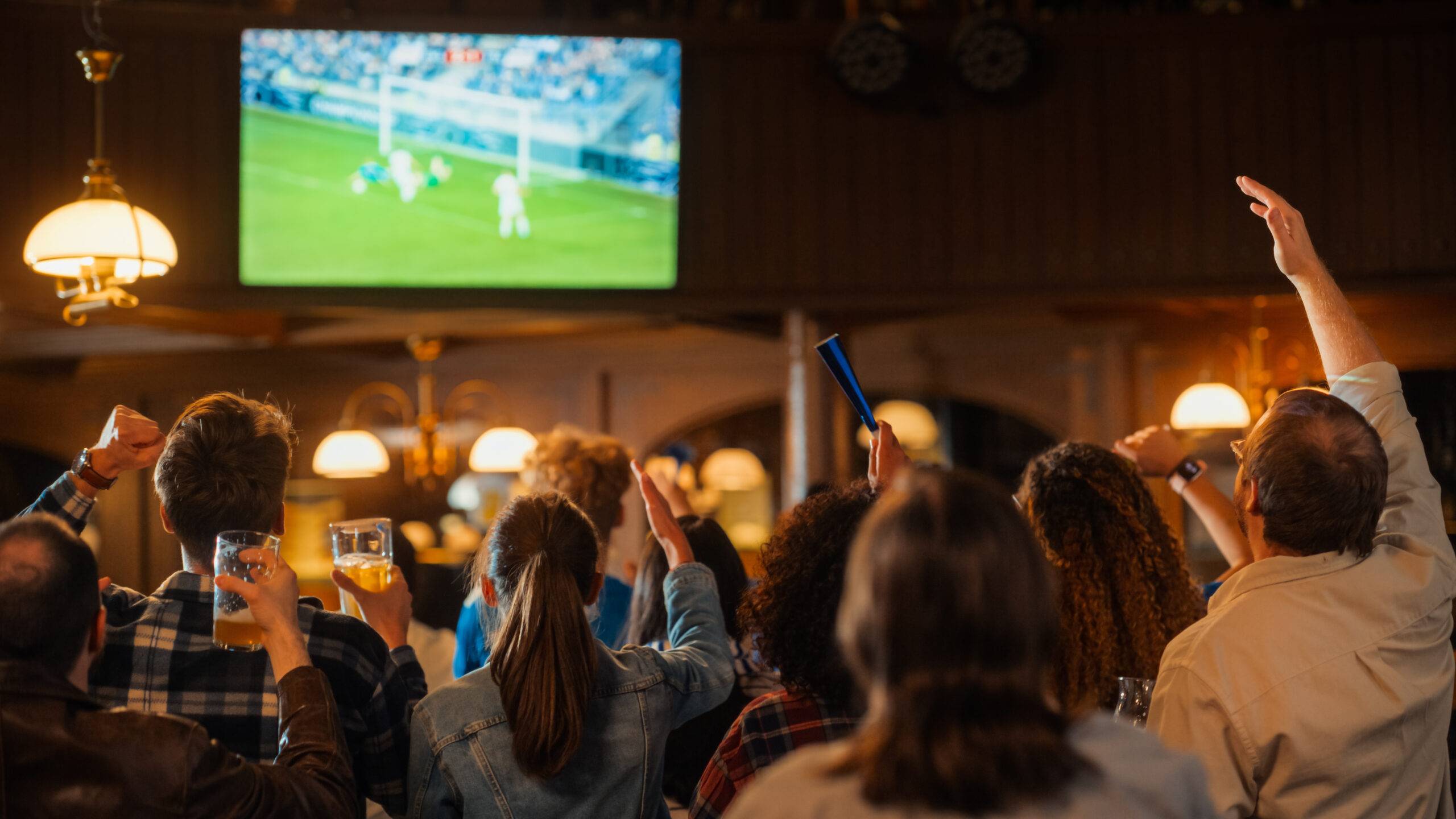 Soccer Club members celebrate in a pub